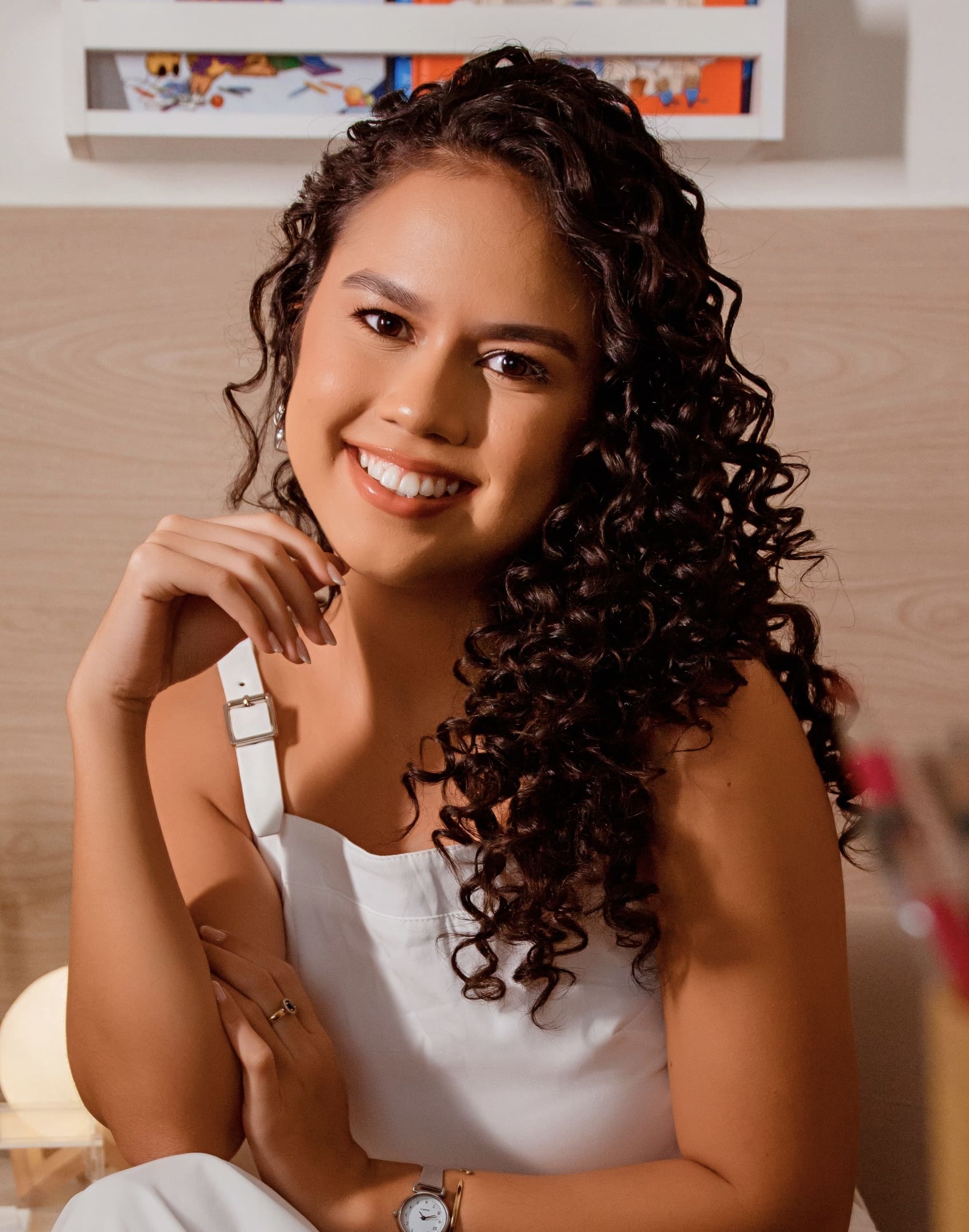 Psicóloga Kauany Araujo sorrindo em ambiente acolhedor de consultório